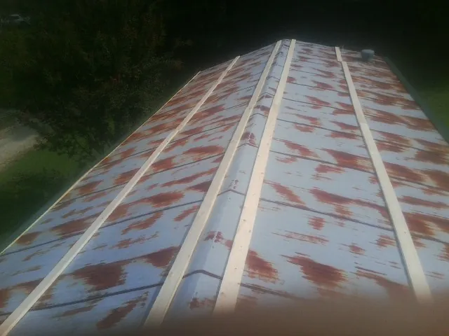 Rusted metal roof panels with new wood purlins before replacement — Storm Damage Roof Repair in Grindstone by Roofing Brothers
