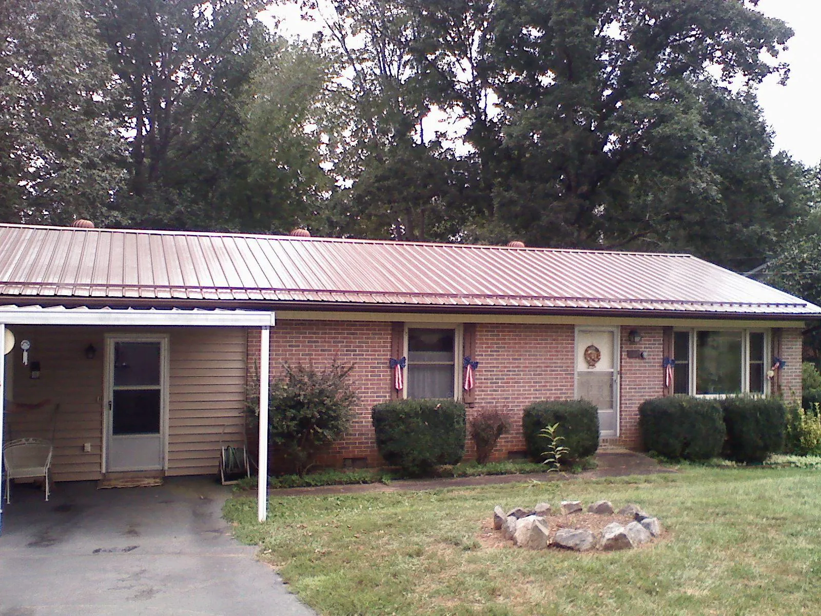 Bronze metal roof and carport on a brick ranch home — Roof Repair work by our crew in Grindstone